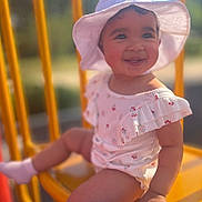Spencer is registered to the contest to win money with this photo: toddler, child, smiling, hat, sunhat, outdoor, yellow_chair, cute, happy, summer, clothing, baby, portrait, sitting, sunlight, blurry_background, cute_outfit, face, person, cheerful