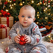 Darla joined the competition — help win amazing prizes! baby, celebration, child, christmas_ornament, christmas_tree, cozy, cute, decorations, face, festive, gift, holiday, indoor, lights, pajamas, present, sitting, smiling, toy_train, winter