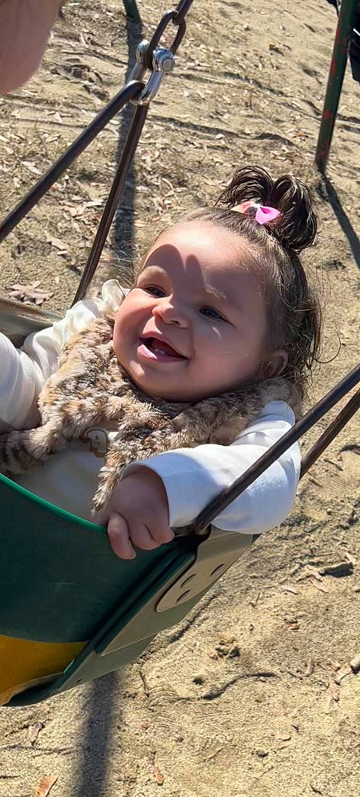 Rhea is registered to the contest to win money with this photo: baby, baby_laughing, baby_toddler_clothing, cheek, child, city, fun, grass, happy, head, leisure, outdoor_play_equipment, people_in_nature, person, recreation, skin, smile, swing, toddler, tree