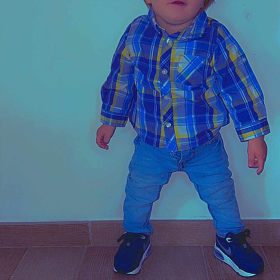 Ezio participe au concours pour gagner de l'argent avec cette photo : blue_eyes, casual_clothing, child, curious_expression, cute, flooring, footwear, indoor, jeans, person, plaid_shirt, portrait, short_hair, small_hands, sneakers, standing, toddler, wall, wooden_floor, young_child