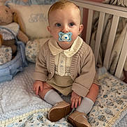 Albie joined the competition — help win amazing prizes! baby, child, pacifier, crib, blanket, stuffed_toy, socks, cardigan, nursery, soft_toys, cute, seated, indoors, infant, clothing, footwear, pillow, decor, warm_lighting, curious