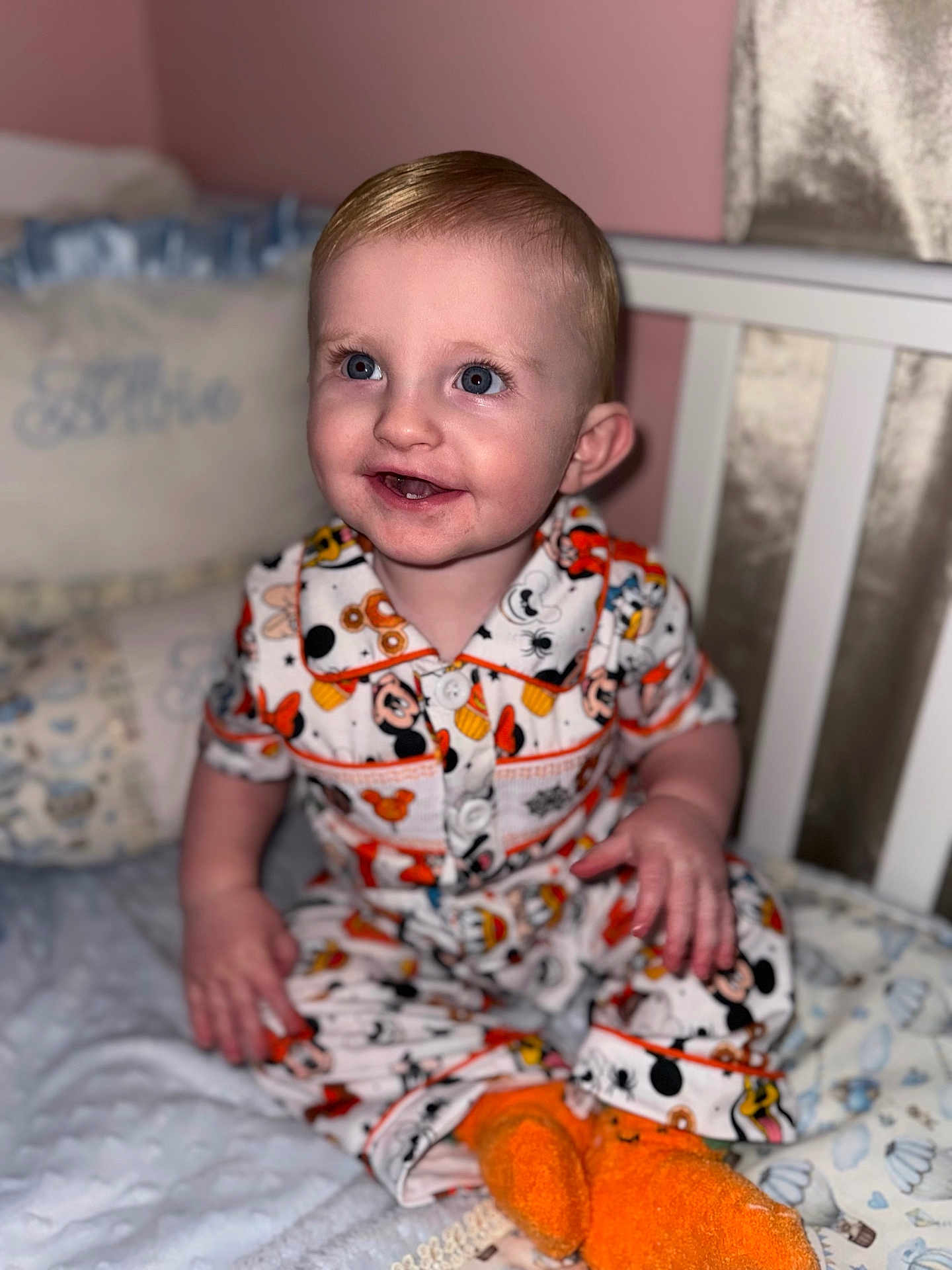Albie joined the competition — help win amazing prizes! toddler, child, baby, pajamas, mickey_mouse, orange_socks, bed, blanket, cushion, nursery, smile, face, person, indoor, clothing, cute, happy, seated, infant, portrait