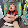 baby, car_seat, smile, happy, toy, foot, child, infant, seatbelt, clothing, indoor, floor, plastic_bag, playful, cute, person, head, hand, legs, childcare