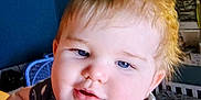 Liam joined the competition — help win amazing prizes! baby, child, blue_eyes, blond_hair, face, infant, indoor, portrait, smile, clothing, pattern, stars, crib, furniture, room, shelf, person, cute, young, closeup