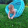 baby, infant, diaper, inflatable, mermaid_tail, pool_toy, grass, outdoor, greenery, child, crawling, summer, playtime, nature, sunlight, hedge, young_child, cute, curious, skin