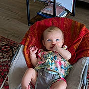 áine joined the competition — help win amazing prizes! baby, infant, bouncer, thumb_sucking, colorful_clothing, indoor, carpet, table, books, floor, furniture, person, cute, child, home, relaxing, patterned_rug, wood_floor, small_table, baby_trend