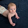 baby, infant, diaper, blue_eyes, lying_down, blanket, pillow, indoor, curious, child, skin, young, sleeping_area, cozy, toddler, face, person, resting, cute, expression