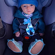 Richard joined the competition — help win amazing prizes! baby, infant, child, car_seat, vehicle, buckled, blue_clothing, winter_clothing, hat, jacket, pacifier, baby_shoes, fuzzy_booties, sitting, portrait, indoors, transportation, safe, serious_expression, closeup