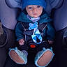 baby, infant, child, car_seat, vehicle, buckled, blue_clothing, winter_clothing, hat, jacket, pacifier, baby_shoes, fuzzy_booties, sitting, portrait, indoors, transportation, safe, serious_expression, closeup
