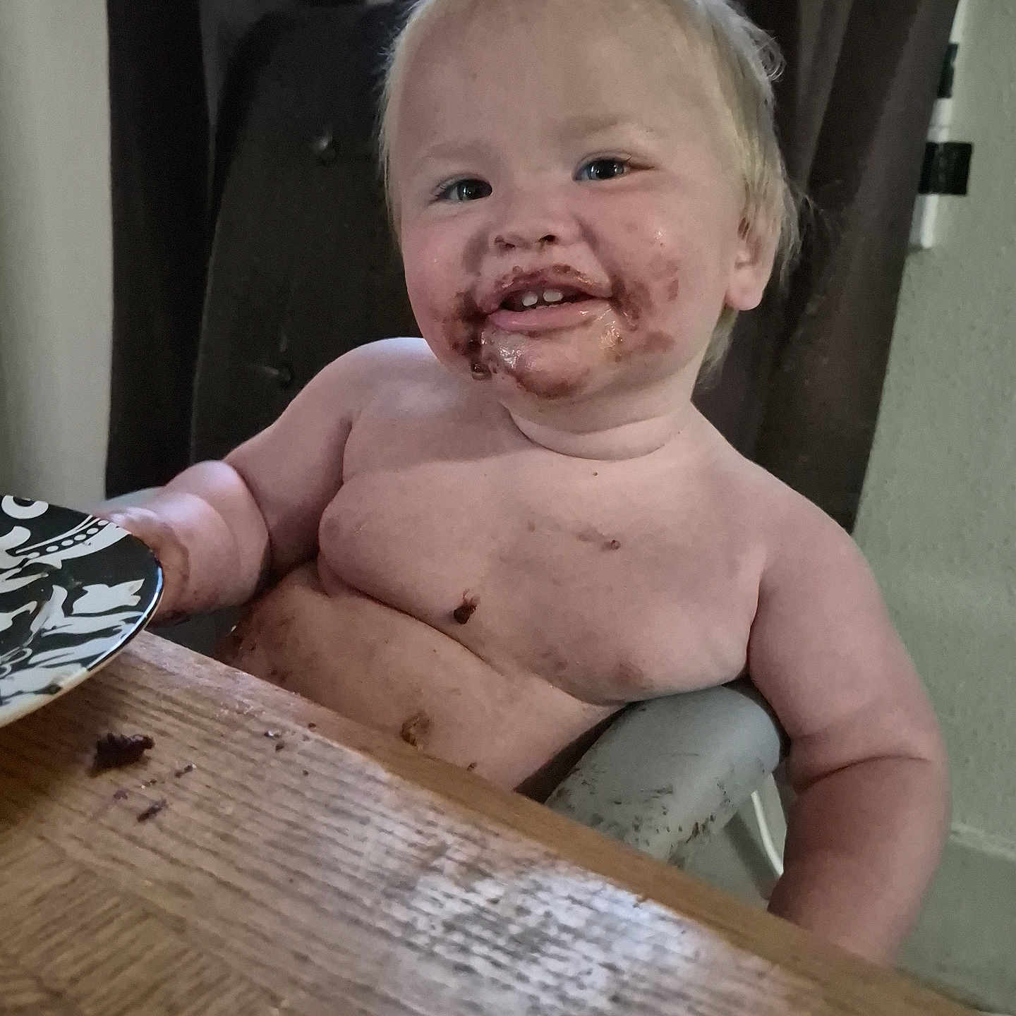 Jozeff is registered to the contest to win money with this photo: toddler, child, smiling, chocolate, messy, face, table, wood, highchair, indoor, light, happy, cute, skin, hair, food, meal, sitting, baby, dirt