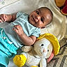 baby, bed, blanket, child, clothing, comfort, cute, fabric, face, happy, indoor, infant, lying_down, plush_toy, portrait, smile, soft, stuffed_animal, yellow_boots, yellow_hat