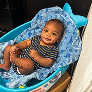 Darius Jr is registered to the contest to win money with this photo: baby, infant, blue, blanket, baby_tub, striped_clothing, smiling, happy, cute, child, indoors, playful, onesie, foot, hand, face, eyes, head, skin, relaxing