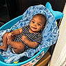 baby, infant, blue, blanket, baby_tub, striped_clothing, smiling, happy, cute, child, indoors, playful, onesie, foot, hand, face, eyes, head, skin, relaxing