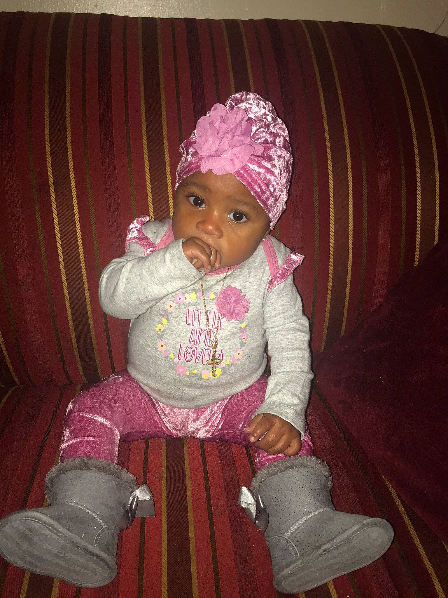 Skylah is registered to the contest to win money with this photo: baby, baby_toddler_clothing, boot, cap, chair, cheek, child, comfort, couch, curtain, fashion_accessory, fun, happy, headwear, knit_cap, lap, magenta, person, pink, purple