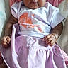 Rose is registered to the contest to win money with this photo: baby, infant, child, clothing, skirt, shirt, pink_blanket, lying_down, portrait, cute, small_hands, socks, striped_socks, indoors, person, young_child, face, looking_at_camera, soft_fabric, cozy