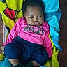 baby, sleeping, blanket, pink_shirt, navy_pants, floor, indoor, child, clothing, footwear, cozy, cute, peaceful, infant, portrait, resting, homedecor, colorful, young_child, person