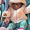 baby, child, hoodie, pink, fluffy, blanket, stroller, booties, cute, warm_clothing, infant, seated, portrait, soft_texture, indoor, cozy, person, apparel, colorful, expression