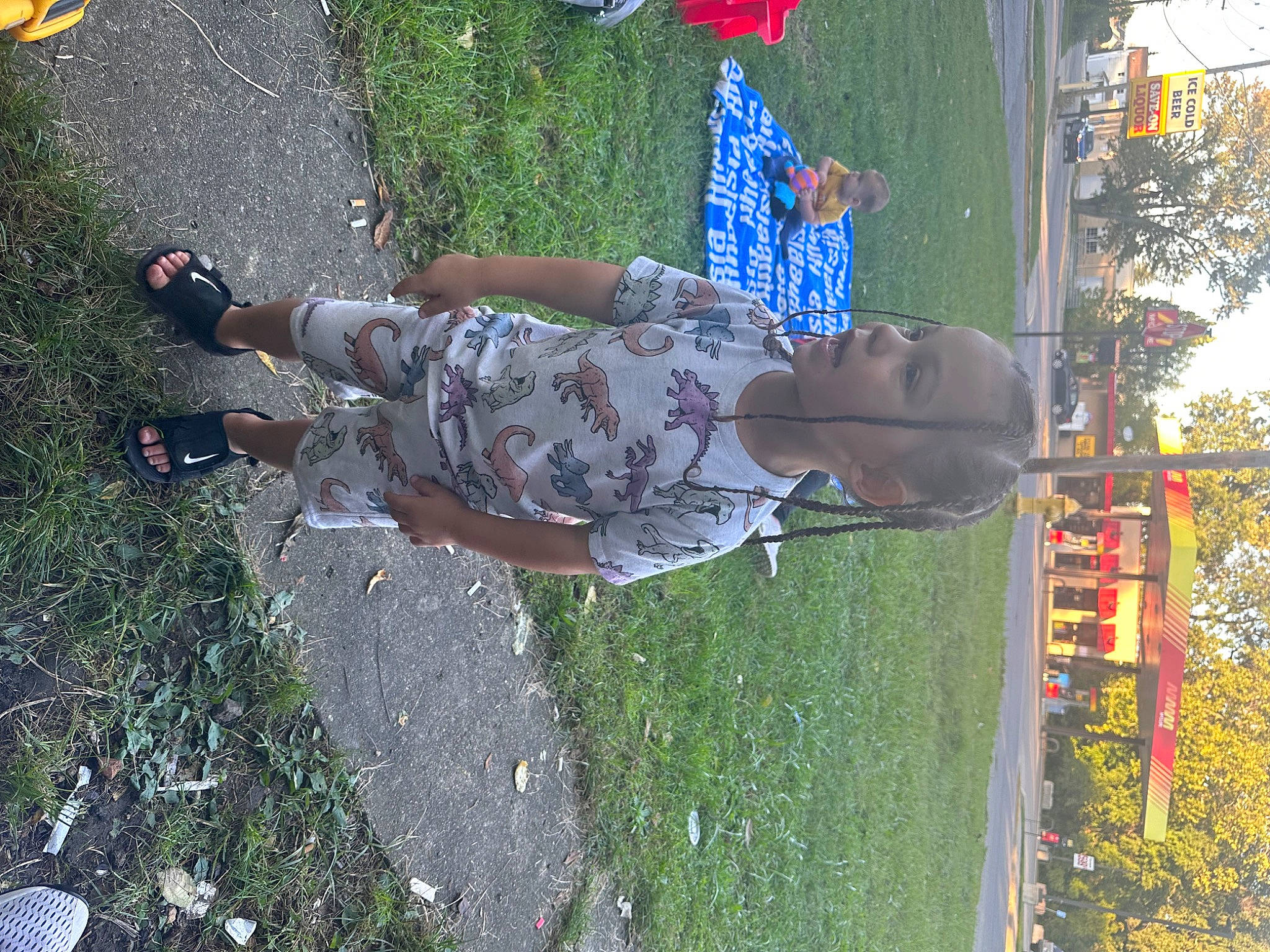 Kamarion is registered to the contest to win money with this photo: foot, fun, grass, human_leg, leisure, pattern, people_in_nature, person, plant, pole, recreation, sandal, shadow, sidewalk, thigh, toddler, tree, visual_arts, water