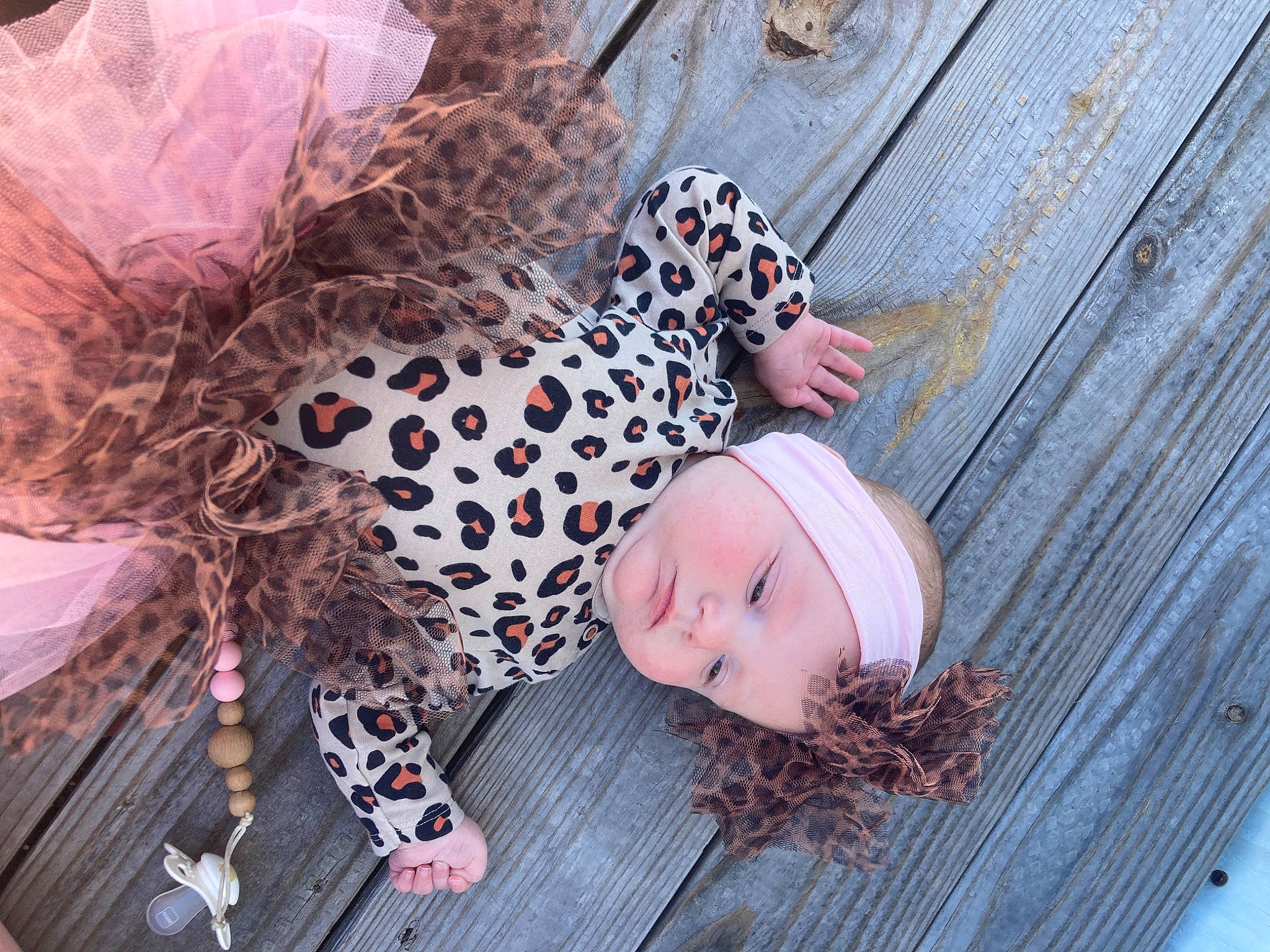 Sadie Mae is registered to the contest to win money with this photo: beanie, child, eyewear, fashion_accessory, flooring, fur, grass, headgear, headwear, human_leg, jewellery, pattern, person, photo_shoot, portrait_photography, sitting, sunglasses, textile, toddler, twig
