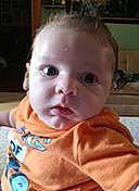 Owen is registered to the contest to win money with this photo: baby, baby_toddler_clothing, bib, cheek, child, chin, comfort, crying, ear, eyelash, fun, happy, head, iris, mouth, nose, person, sitting, sleeve, smile