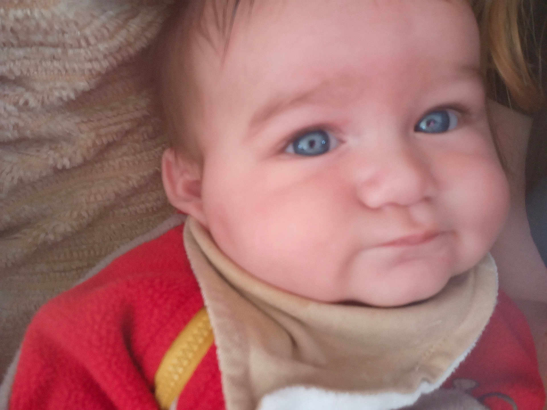 Ezio Jegu a rejoint le concours — aidez-le/la à gagner de superbes lots ! baby, child, face, blue_eyes, cheeks, bib, clothing, closeup, expression, infant, person, portrait, red_clothing, skin, soft_texture, young, cute, head, smile, indoors