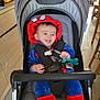 baby, blue, child, costume, cute, floor, happy, hood, indoor, infant, pacifier, red, seatbelt, sitting, smiling, spiderman, stroller, tongue_out, toy, wooden_furniture