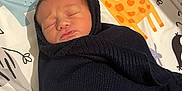 Ezio participe au concours pour gagner de l'argent avec cette photo : baby, bed, bedroom, blanket, clothing, crib, face, furniture, hat, head, indoors, infantbed, knitwear, newborn, person, photography, portrait, room, sleeping, sweater