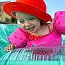 Lyla participe au concours pour gagner de l'argent avec cette photo : toddler, child, smiling, red_hat, pink_floaties, inflatable_pool, water, summer, outdoor, sunny, happy, blue_sky, playful, swimming, cute, fun, vacation, pool_party, joyful, closeup