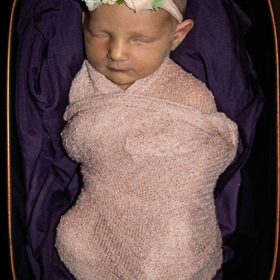 Ensleigh is registered to the contest to win money with this photo: accessories, baby, bed, blanket, bodypart, bonnet, cap, clothing, cradle, crib, dress, face, finger, flower, flowerarrangement, flowerbouquet, furniture, hand, happy, hat