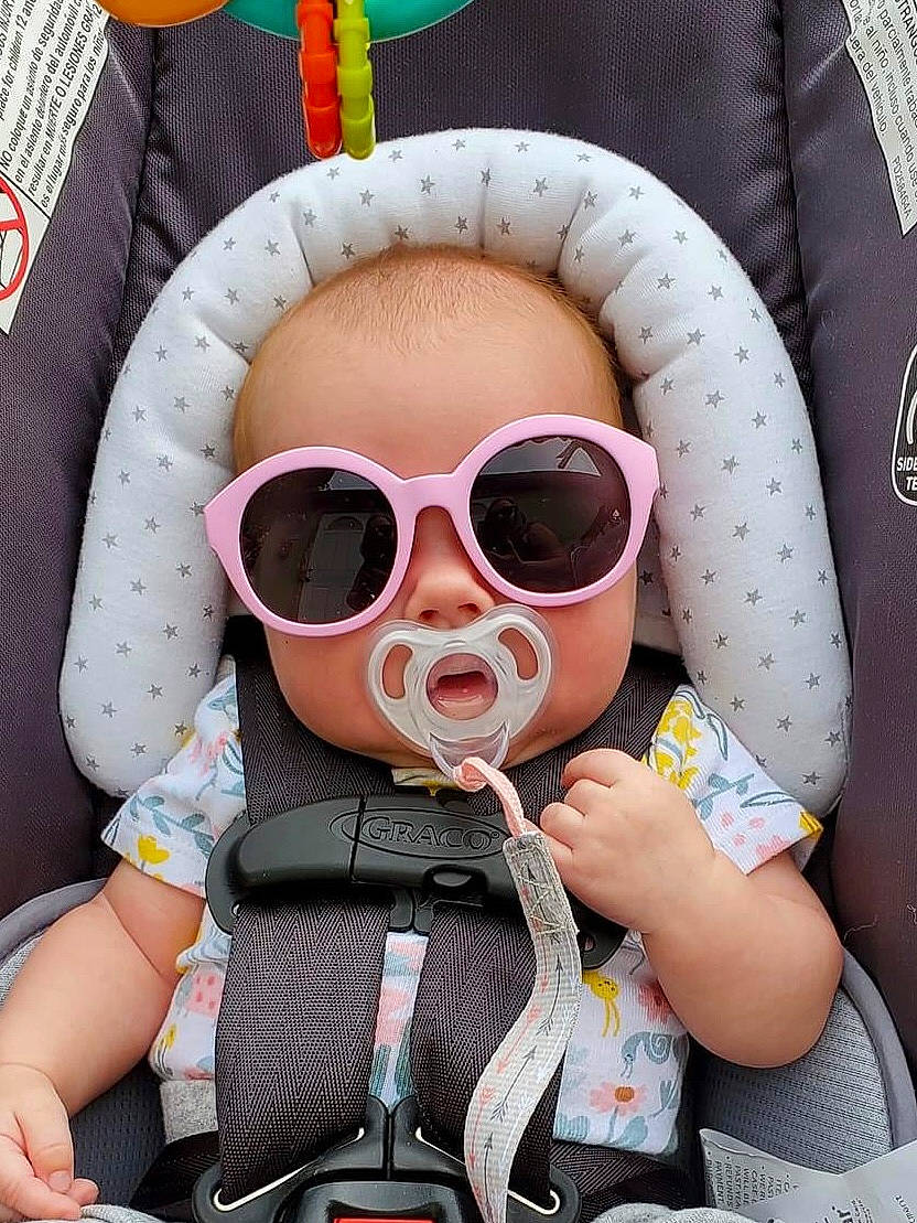 Olivia Ann is registered to the contest to win money with this photo: auto_part, baby, baby_carriage, baby_products, baby_sleeping, baby_toddler_clothing, car_seat, carmine, child, comfort, eyewear, goggles, pattern, person, personal_protective_equipment, pink, product, sleeve, sunglasses, toddler