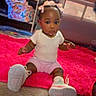 Azianna joined the competition — help win amazing prizes! baby, child, indoor, pink_rug, sneakers, white_shirt, pink_shorts, bow, hair_accessory, carpet, playpen, sitting, floor, toys, shelf, storage_bag, cute, curious, young_child, portrait