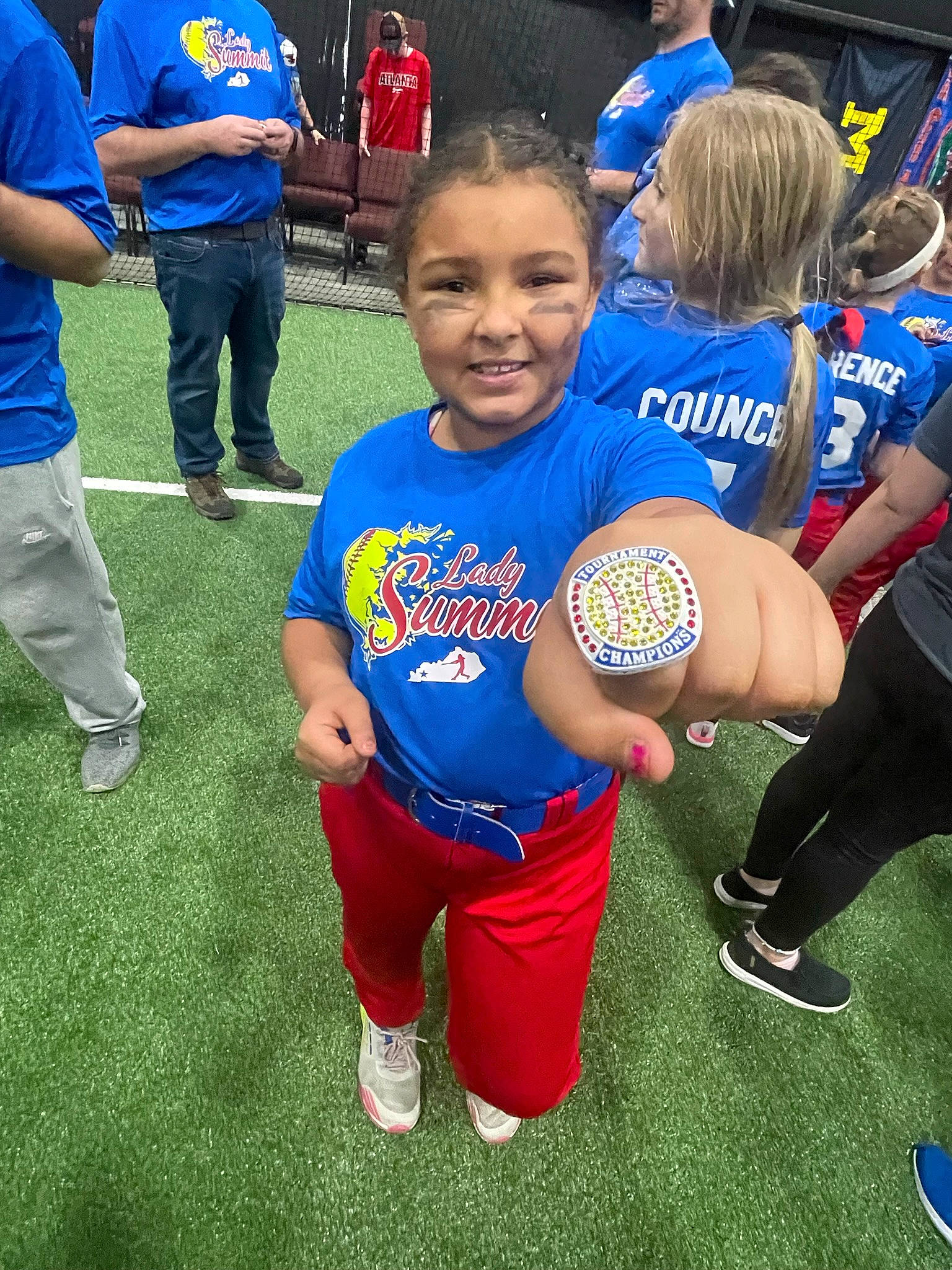 Mia Malone is registered to the contest to win money with this photo: ball, ball_game, blue, football, footwear, fun, grass, jersey, joy, leg, mammal, person, player, shoe, shorts, smile, sneakers, sports_equipment, sports_uniform, sportswear