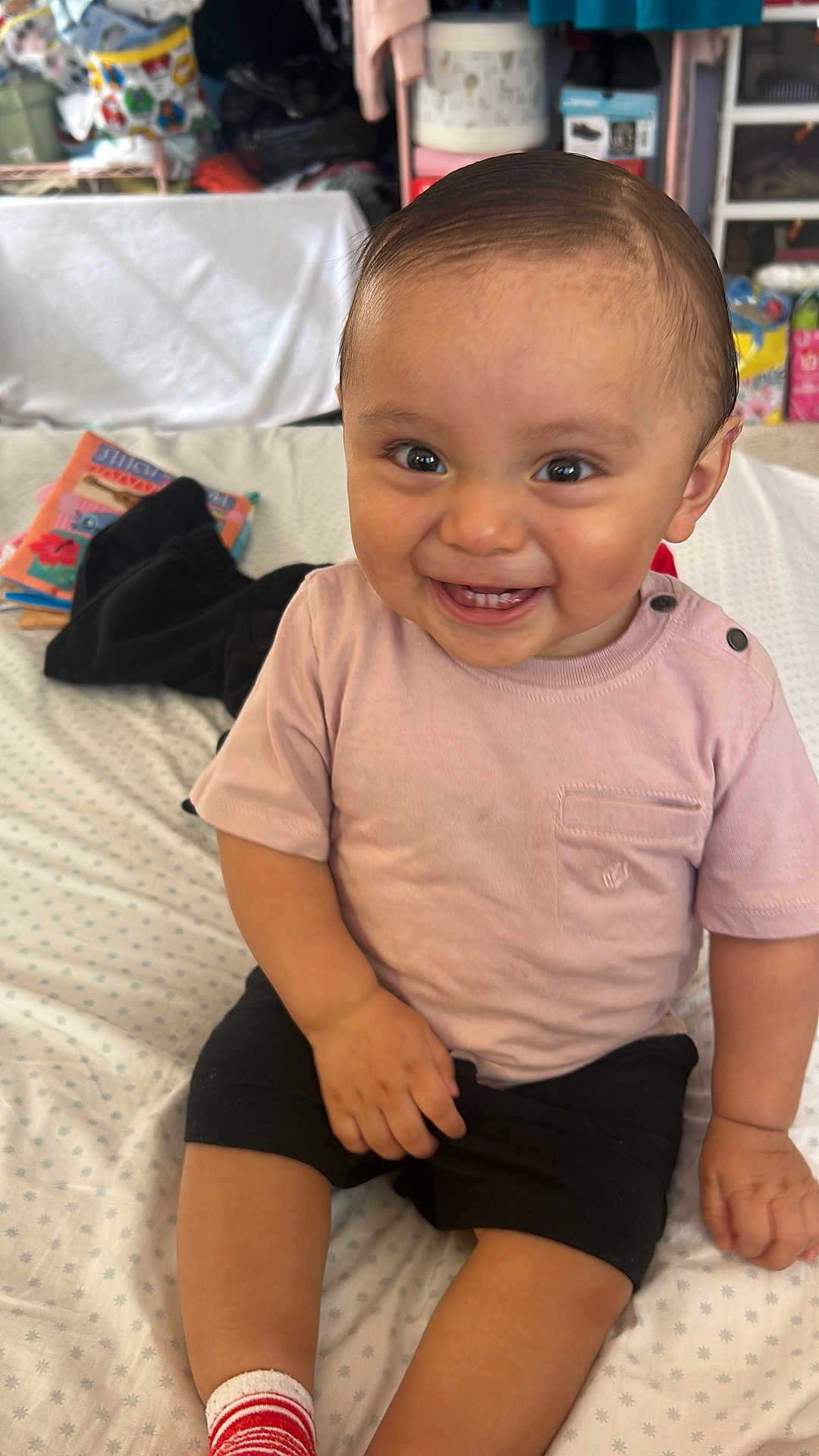 Andres joined the competition — help win amazing prizes! toddler, child, smiling, sitting, indoors, bed, clothing, shorts, tshirt, sock, toy, background, happy, face, person, cute, young_child, home, casual, skin