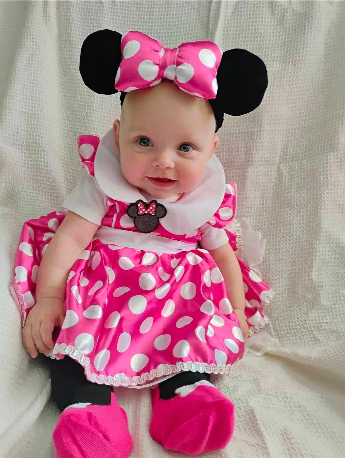 Historia is registered to the contest to win money with this photo: baby, child, dress, pink, polka_dot, headband, bow, smiling, sitting, cute, costume, white_background, infant, person, footwear, sock, happy, indoors, portrait, playful