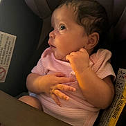 Soraya is registered to the contest to win money with this photo: baby, infant, car_seat, pink_onesie, child, face, hand, looking_sideways, curious, seatbelt, indoors, soft_light, portrait, young_child, newborn, clothing, seat, captive, sitting, person