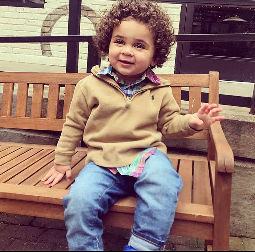 Kayne is registered to the contest to win money with this photo: cheek, child, child_model, cool, denim, eye, face, footwear, human, jacket, jeans, male, outerwear, people, person, shoe, sitting, smile, standing, t_shirt