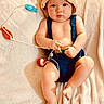 Waylon joined the competition — help win amazing prizes! baby, bare_feet, blanket, blue_outfit, child, colorful, cozy, crocheted_hat, handmade_clothing, indoor, infant, lying_down, photography, portrait, seated, serious_expression, smiling, soft_lighting, textile, yarn