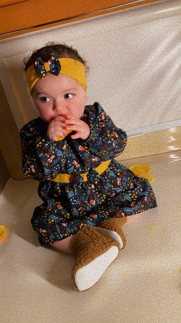 Nelya participe au concours pour gagner de l'argent avec cette photo : baby, baby_toddler_clothing, cap, chair, child, flooring, fun, head, human_leg, knee, leg, outerwear, pattern, person, room, sitting, sleeve, sock, thigh, toddler