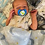 baby, blanket, child, cozy, cute, dinosaur, face, hand, indoors, infant, lying_down, newborn, pacifier, patterned, portrait, quilt, resting, sleep, sleepwear, soft