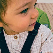 Garance participe au concours pour gagner de l'argent avec cette photo : toddler, child, face, profile, knitted_sweater, button, straps, seat, green, curly_hair, long_eyelashes, cute, indoors, portrait, baby, clothing, person, smile, skin, young_child