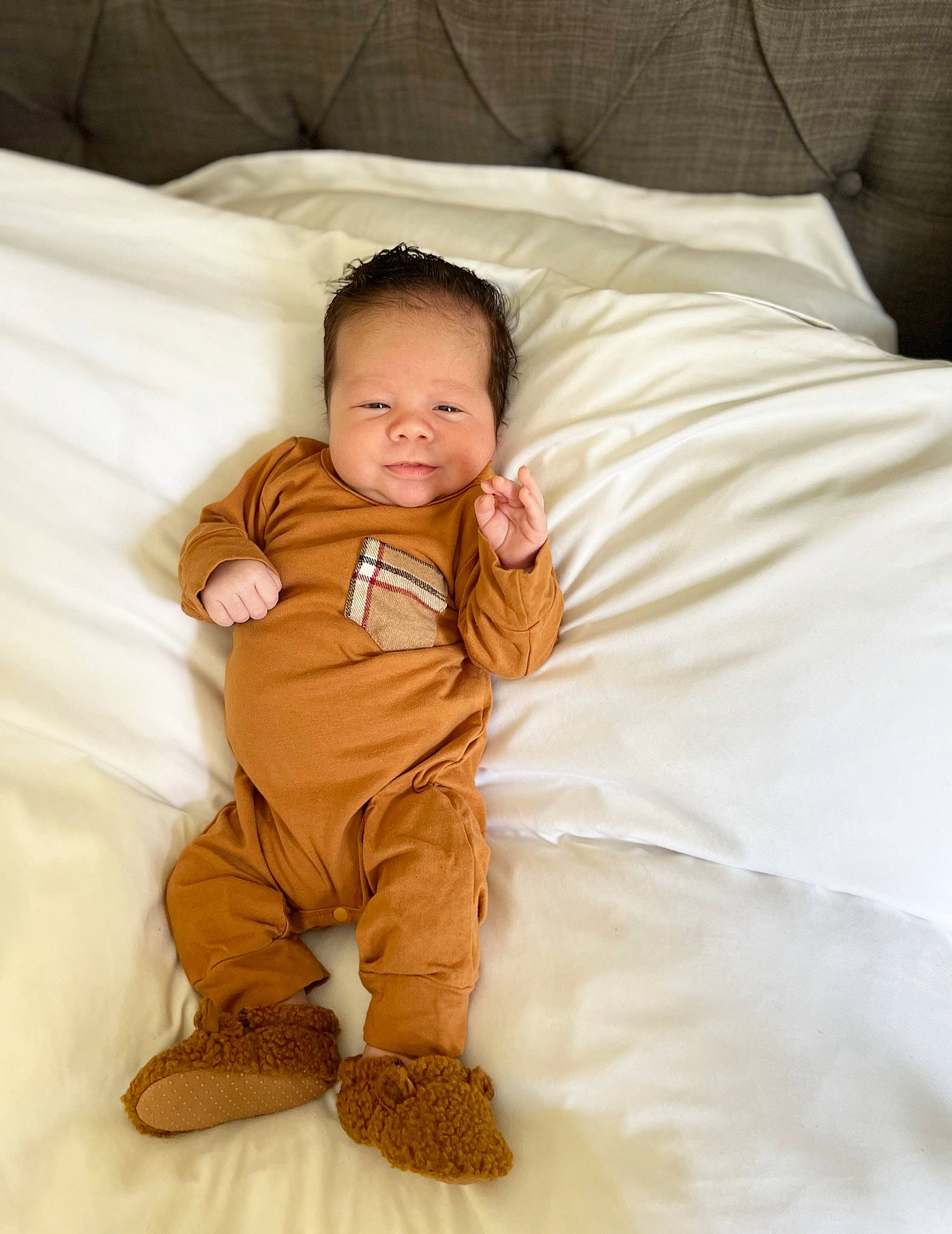 Adan is registered to the contest to win money with this photo: baby, baby_toddler_clothing, bedding, child, comfort, flooring, foot, fur, happy, hardwood, linens, person, pillow, sitting, skin, sleeve, smile, textile, throw_pillow, toddler