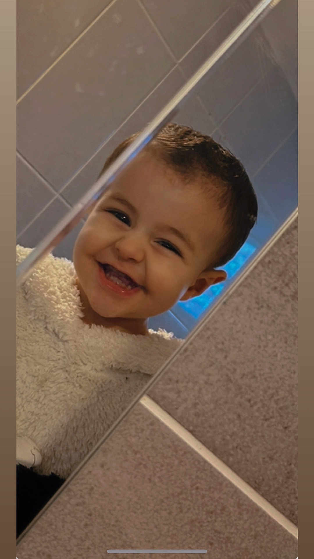 Kelyo a rejoint le concours — aidez-le/la à gagner de superbes lots ! child, toddler, smile, happy, face, mirror, bathroom, tile, reflection, clothing, bathrobe, young_child, cute, person, indoor, portrait, head, hair, skin, expression