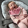 baby, infant, smiling, pink_clothing, bib, baby_seat, gray, cushion, happy, cute, portrait, child, small_hands, cozy, indoors, soft_fabric, newborn, face, joy, relaxed