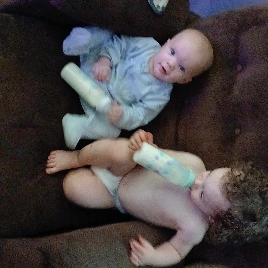 Damon joined the competition — help win amazing prizes! baby, bottle, brown_furniture, carpet, child, clothing, couch, curly_hair, cute, diaper, face, feeding, home, indoors, infant, person, plush, relaxing, sitting, toddler