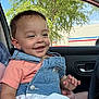 toddler, child, smiling, denim, overalls, earring, car, window, tree, outdoor, clothing, happy, face, person, seat, portrait, casual, daylight, vehicle, joy