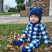 Jedrick is registered to the contest to win money with this photo: toddler, child, blue_hat, checkered_outfit, autumn_leaves, grass, outdoor, cold_weather, baby, hat_with_ears, fuzzy_hat, serious_expression, sitting, sidewalk, brick_house, stairs, greenery, fall, cute, winter_clothing