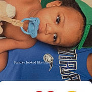 Jessuan is registered to the contest to win money with this photo: baby, blue_shirt, casual, child, clothing, cute, emoji, face, green_cap, hand_gesture, heart_emoji, indoor, infant, lying_down, pacifier, person, relaxed, skin, smiling_face_emoji, text_overlay