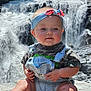 baby, waterfall, outdoor, nature, rock, denim_overalls, headband, chubby_cheeks, sitting, sunlight, greenery, water, cute, portrait, child, summer, adventure, explorer, candid, scenic