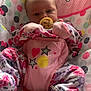 baby, infant, pacifier, onesie, floral_pattern, baby_seat, mickey_mouse, pink, heart, star, polka_dots, cute, child, face, sitting, soft_toys, comfort, indoors, clothing, peaceful