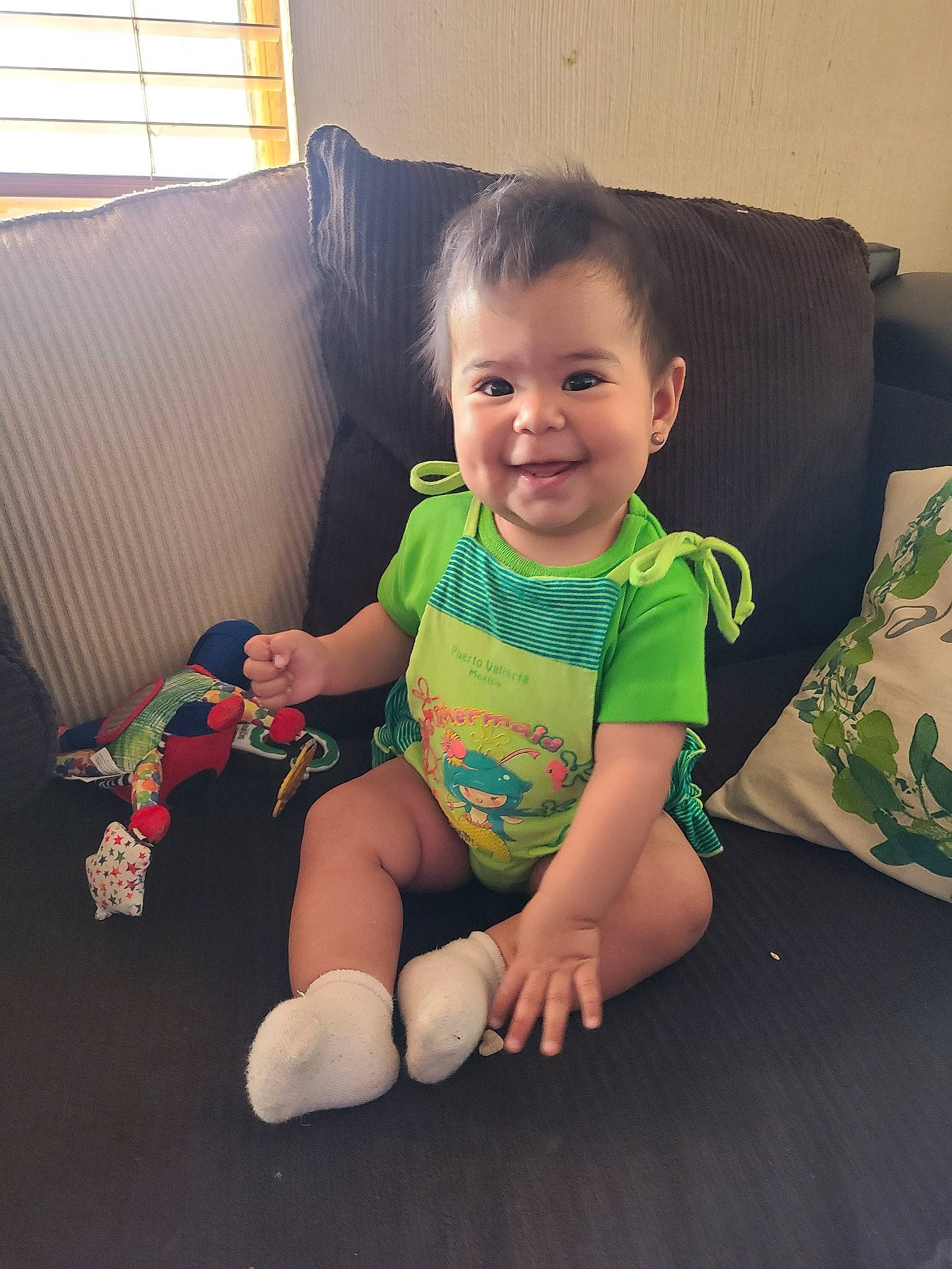 Ema is registered to the contest to win money with this photo: arm, baby, baby_products, baby_toddler_clothing, baby_toys, cheek, child, eye, finger, furniture, head, joy, leg, person, play, room, sitting, skin, smile, textile